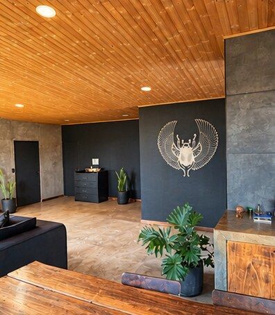 The living room with a white winged scarab on the dark wall